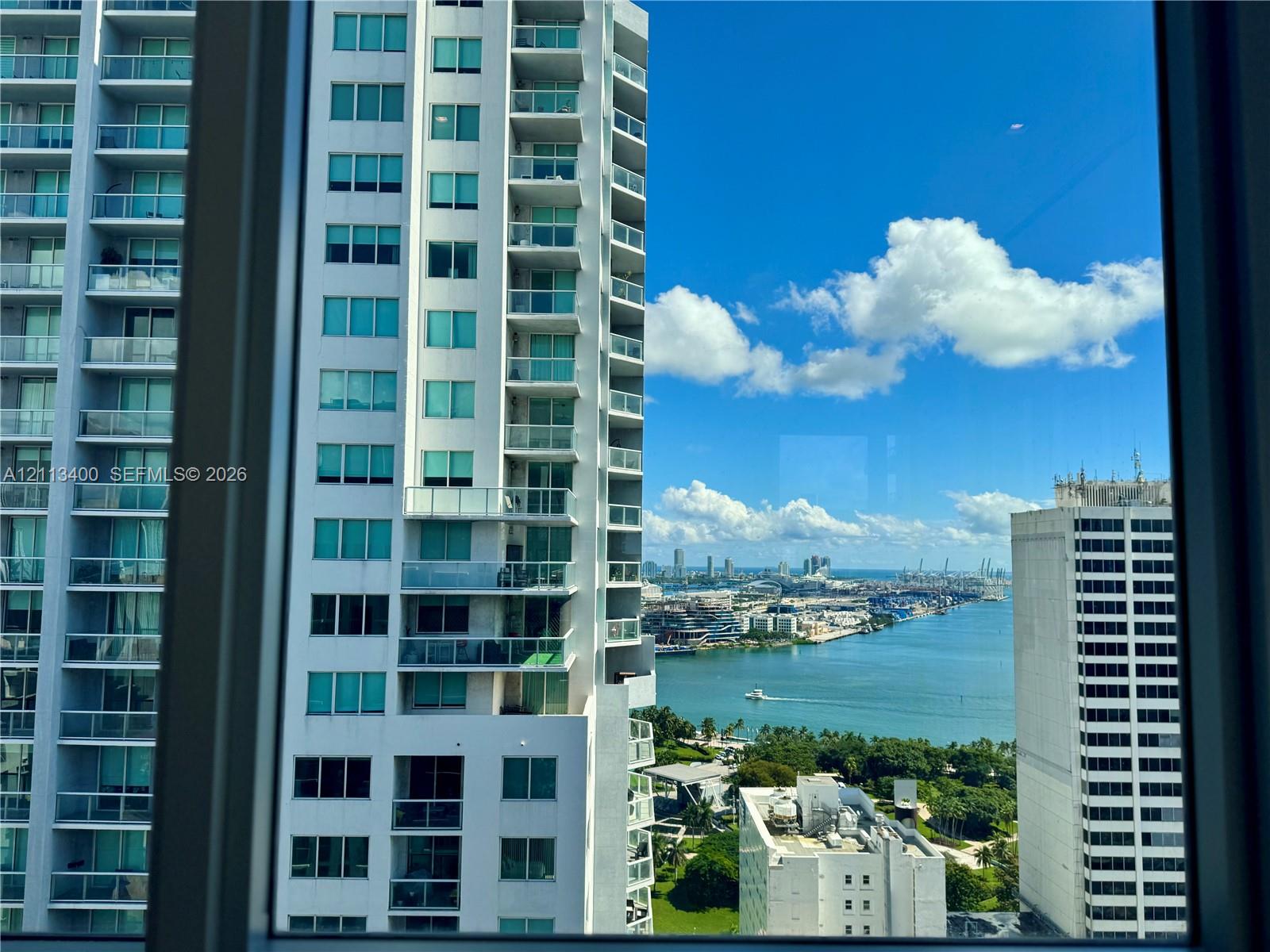 High-rise elevation featuring expansive windows, panoramic water, and urban skyline scenery