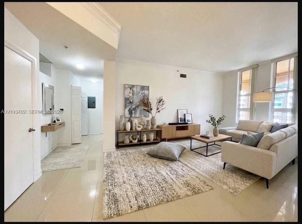 Open-concept room featuring light-toned tile flooring, recessed ceiling lighting, crown molding, and floor-to-ceiling windows