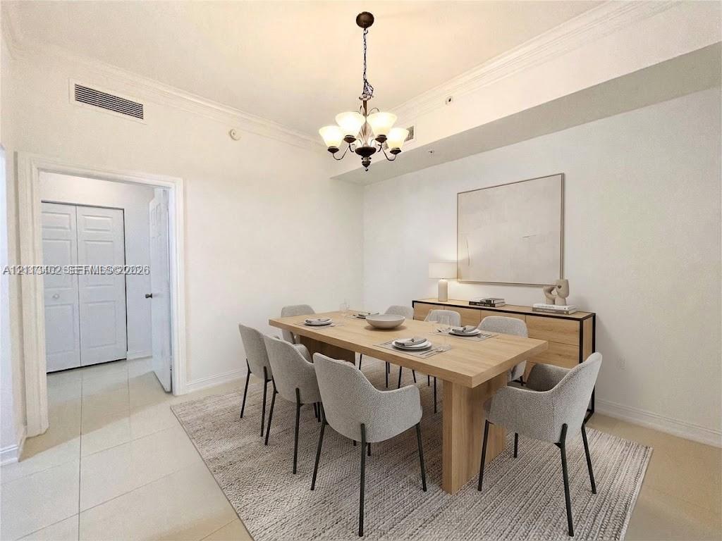 Interior space featuring neutral wall paint, multi-tiered chandelier, crown molding, and large-format tile flooring