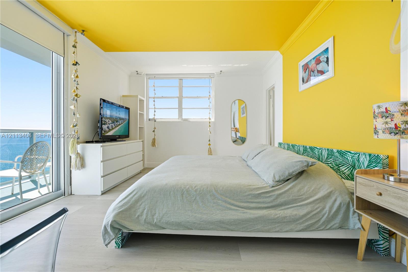 Floor-to-ceiling sliding glass door, wood-finish flooring, accent ceiling and wall, and natural light via large window