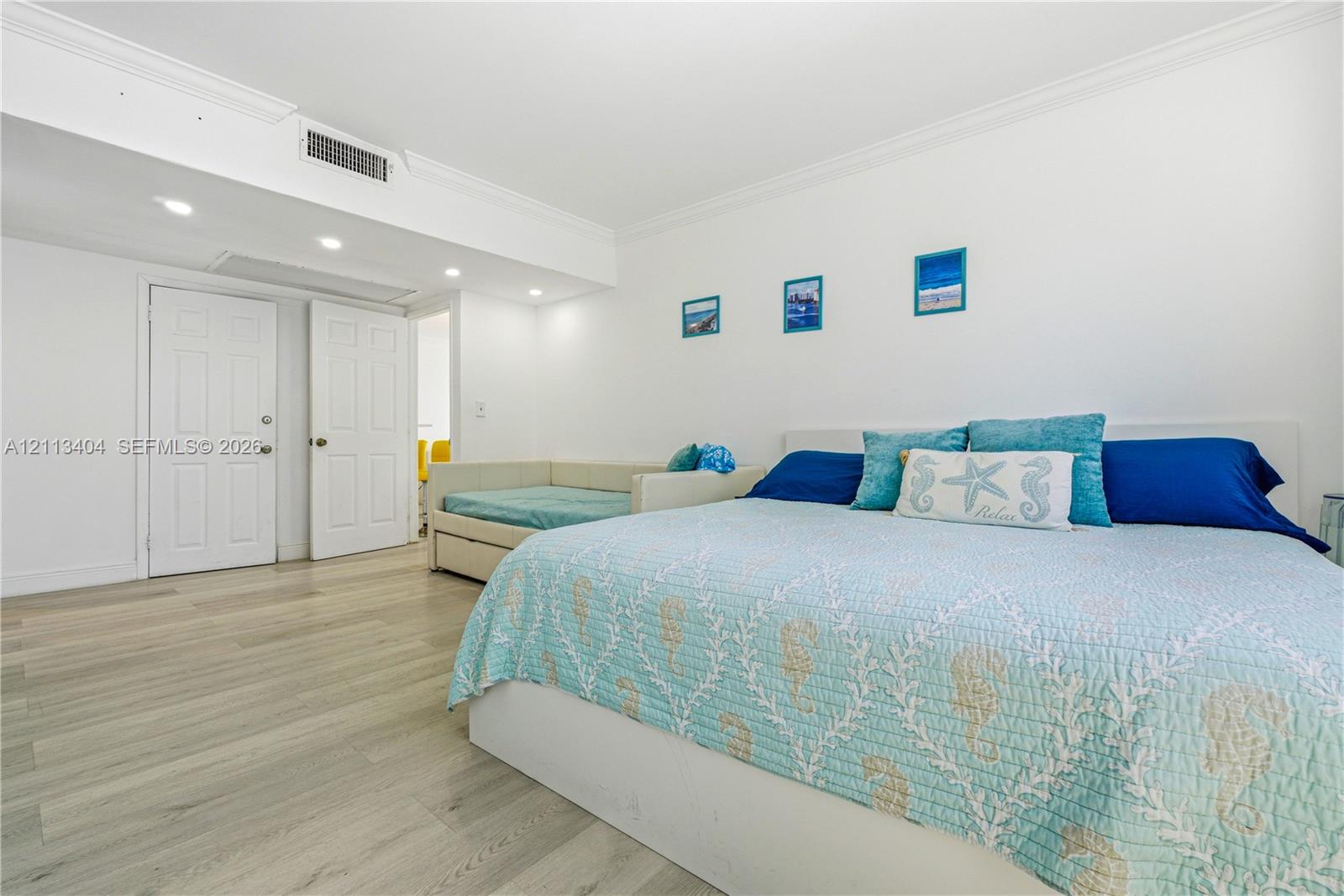 Wood-finish flooring, recessed lighting, and crown molding
