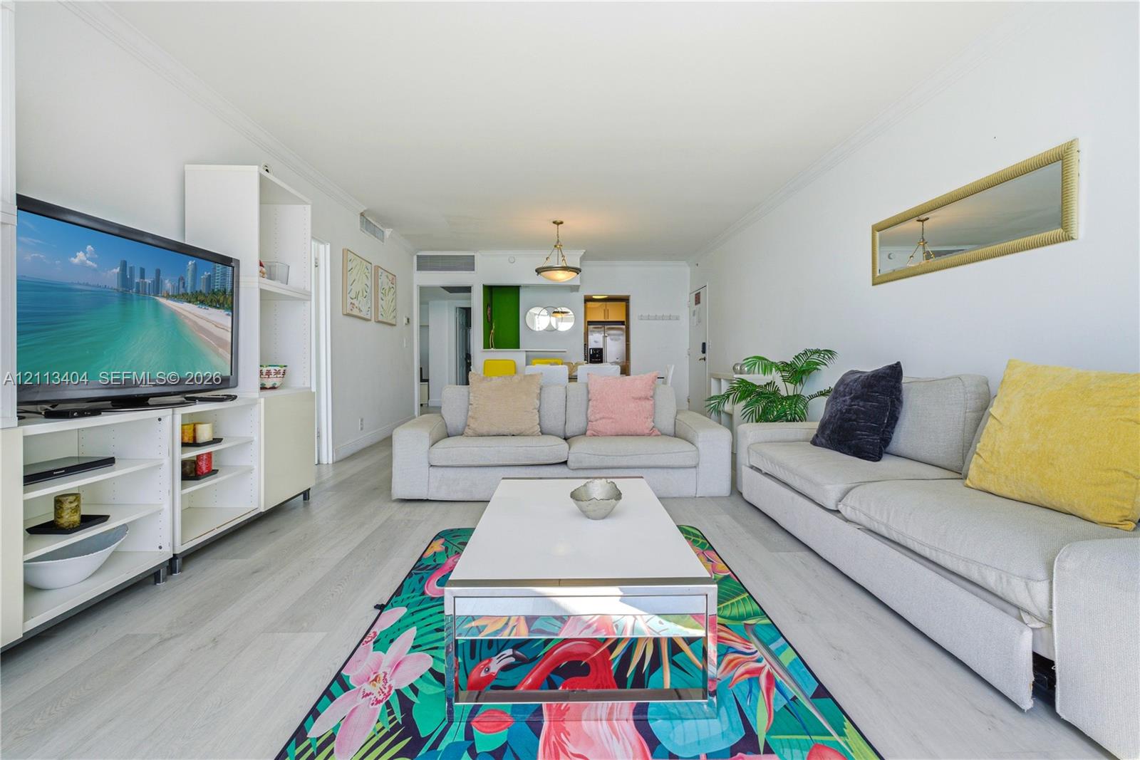Living area featuring wood-finish flooring, built-in shelving, and a decorative hanging light fixture