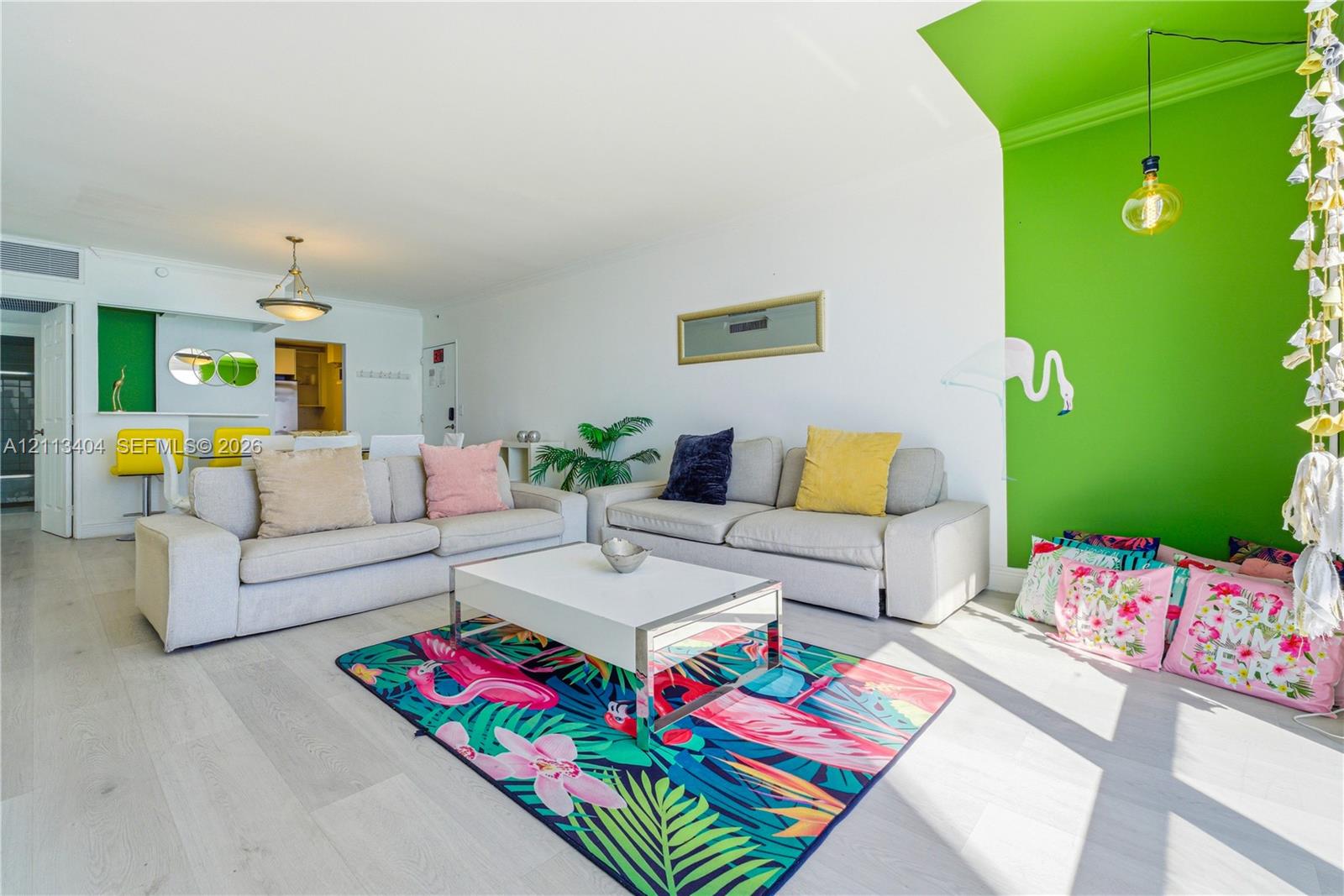 Living area featuring wood-finish flooring, vaulted ceilings, and a distinctive accent wall