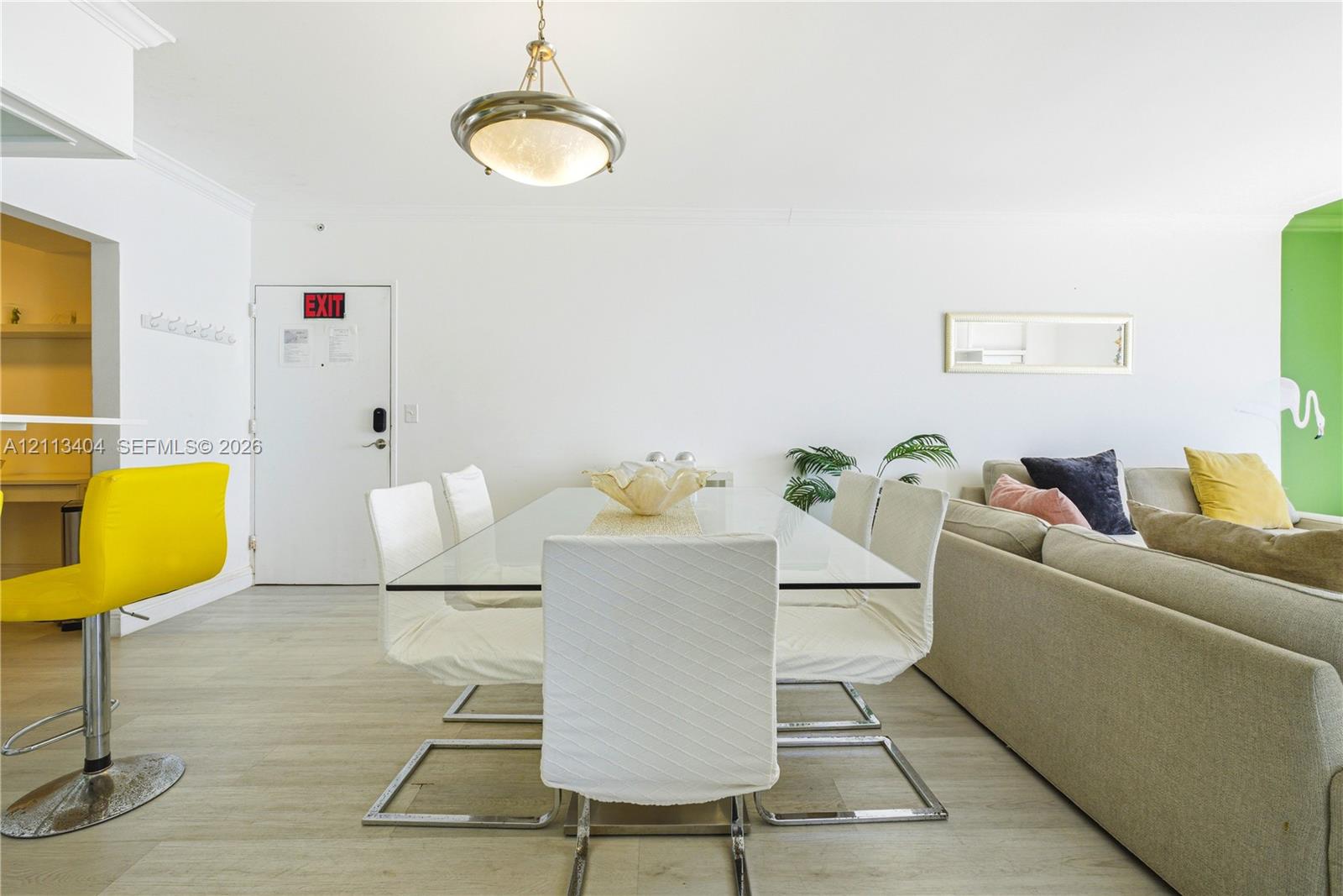 Neutral wood-finish flooring, ceiling-mounted dome light fixture, and recessed wall mirror