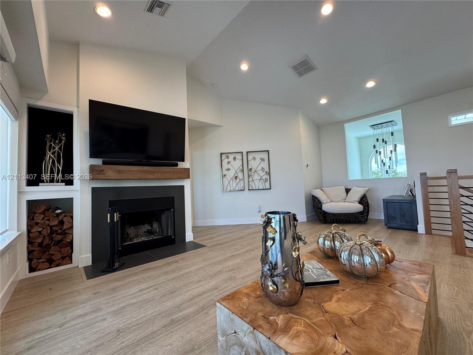 Second floor Fireplace featuring a matte black surround, wood-finish mantel, and built-in alcove shelving