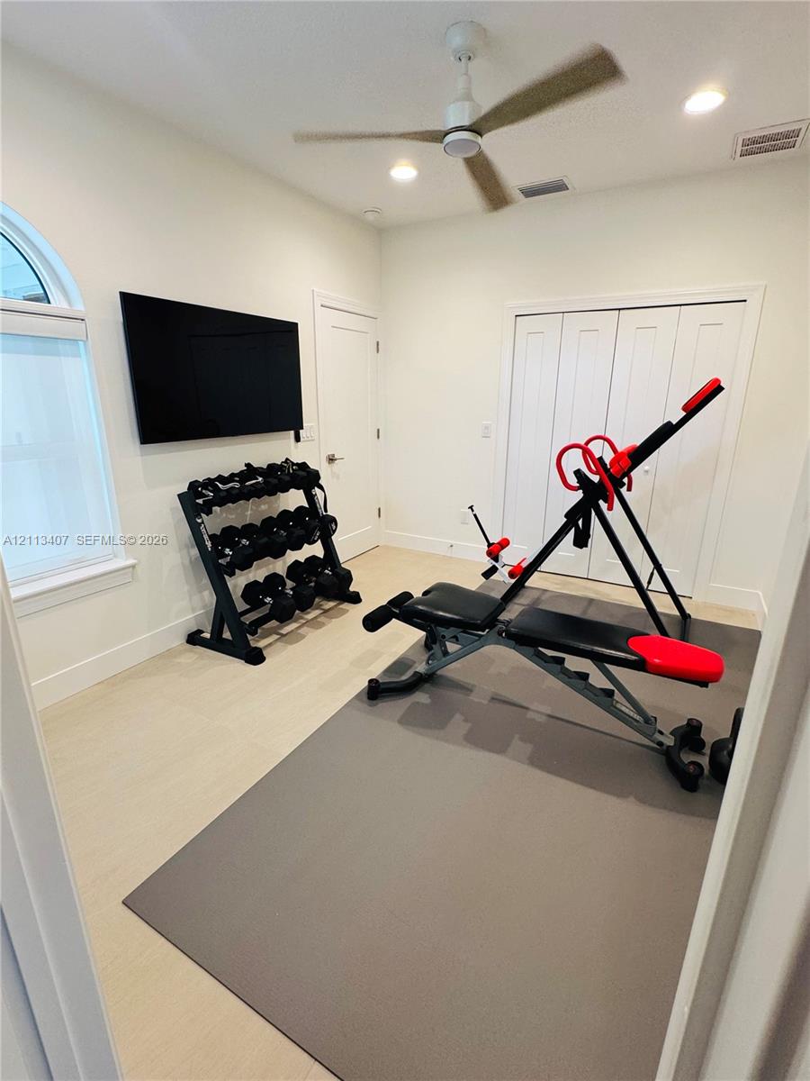Room featuring light-toned flooring, an arched window, recessed lighting, a modern ceiling fan, and bi-fold closet doors