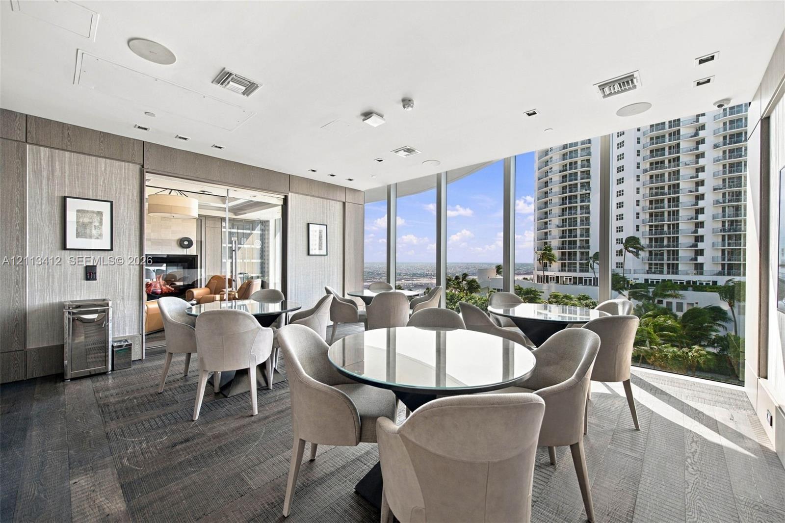 Floor-to-ceiling glass walls, wood-finish flooring, recessed lighting, and wall-mounted paneling