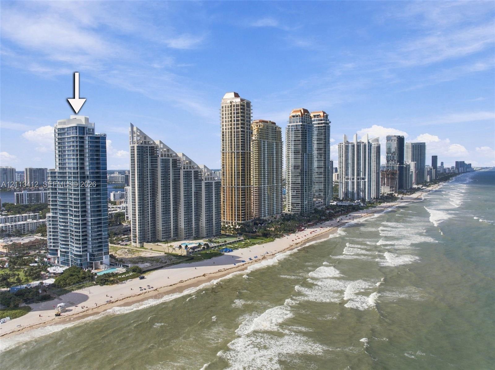 High-rise oceanfront residential tower featuring floor-to-ceiling glass paneling and direct coastal positioning