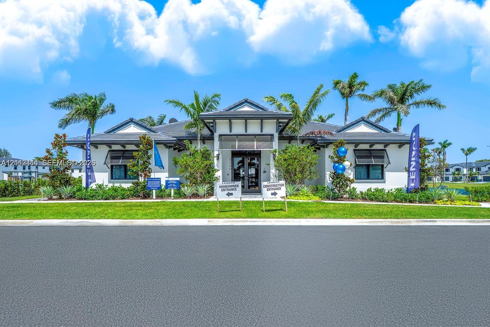 Single-story exterior featuring a hip roof, white stucco facade, dark window awnings, and landscaped perimeter