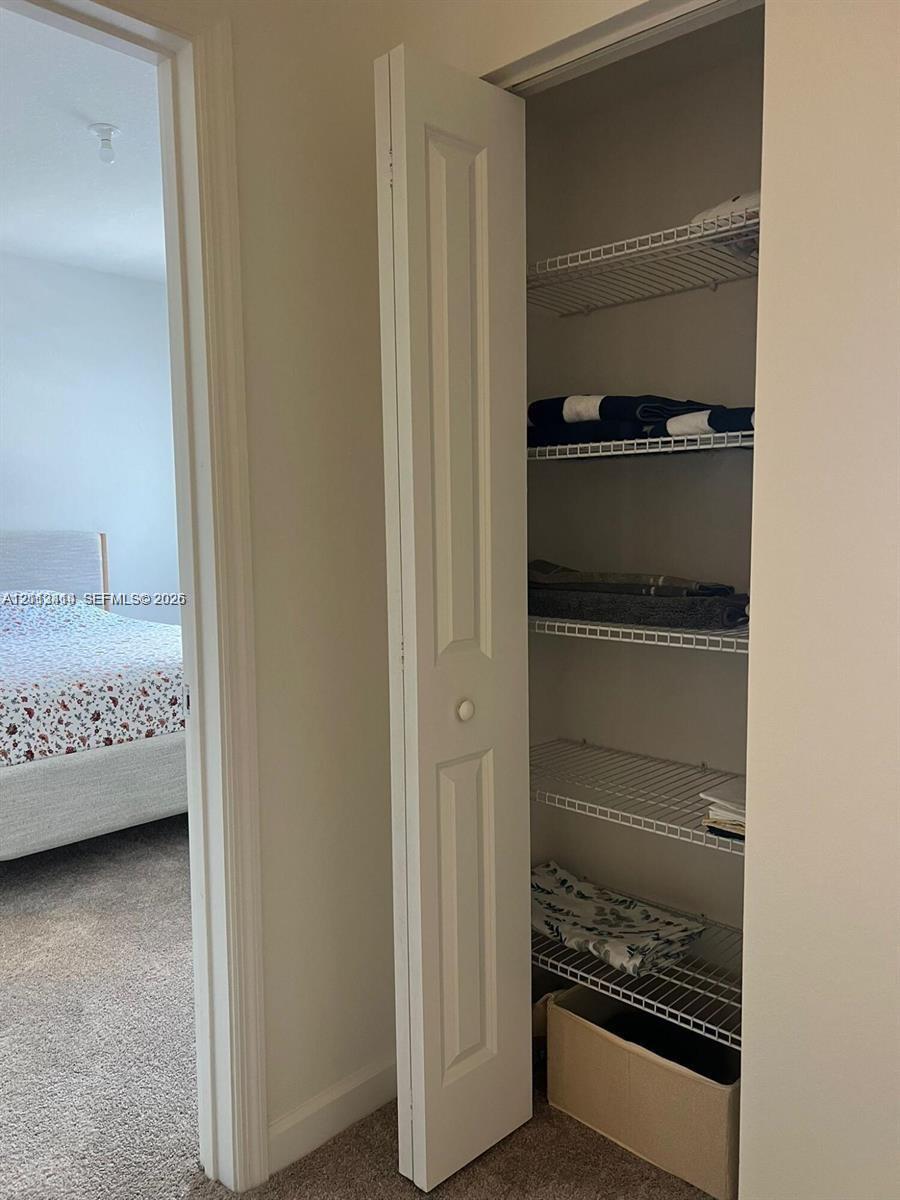 Storage closet featuring white bifold doors and integrated wire shelving