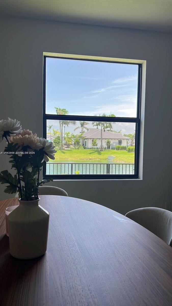 Large single-hung window with a black frame, showcasing water and green space