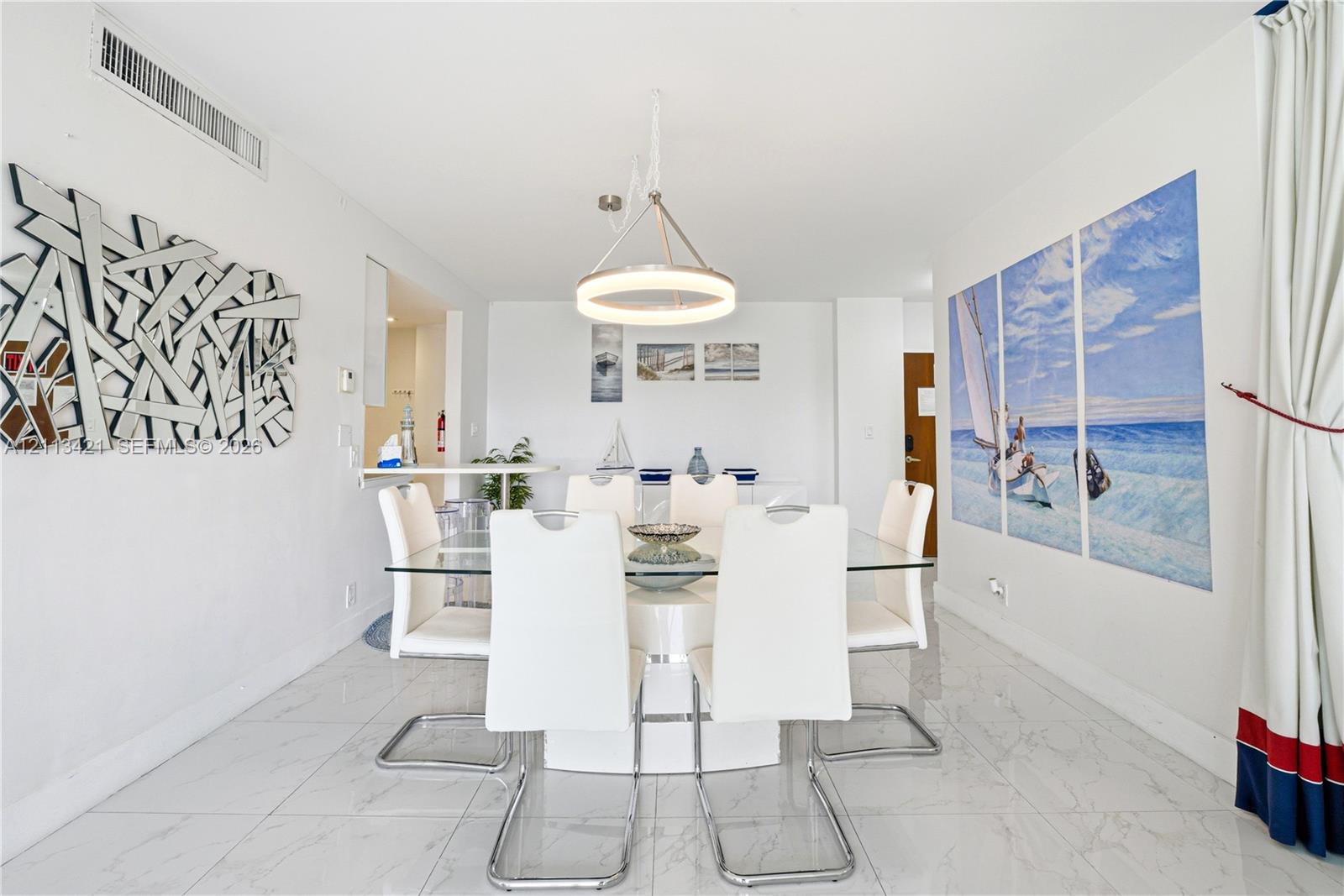 Dining area featuring polished stone-finish tile flooring, a circular tiered chandelier, and a built-in counter surface