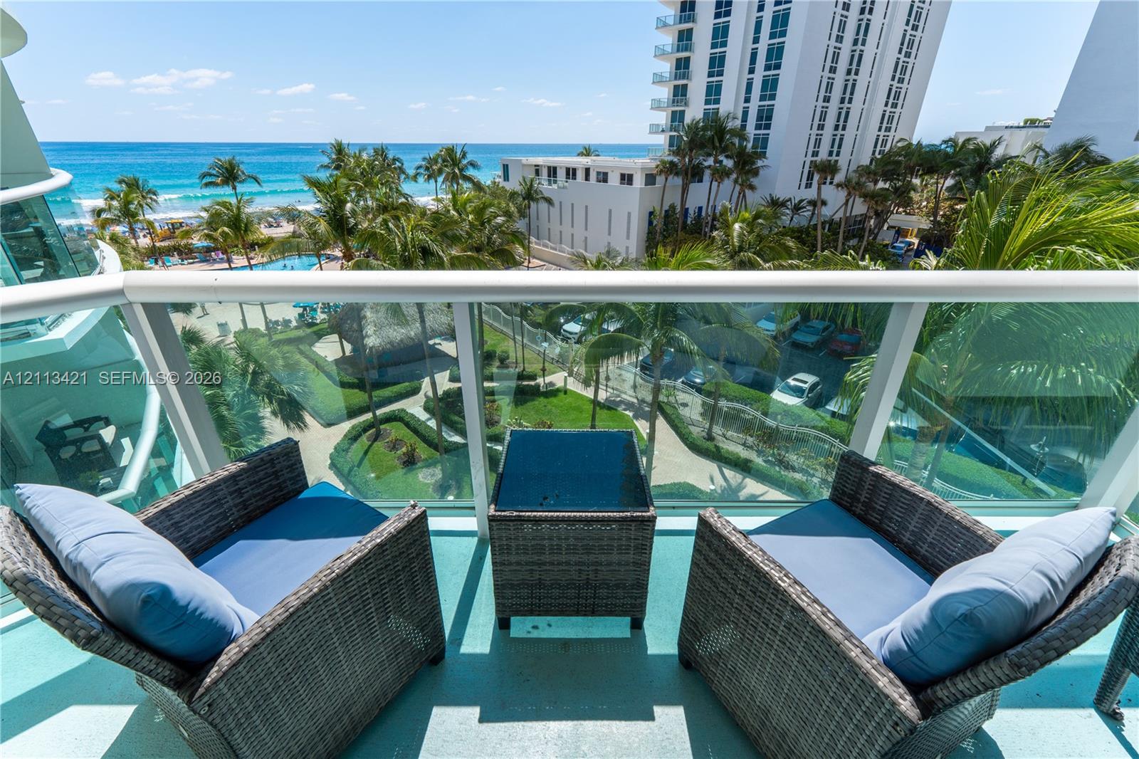Private balcony featuring a glass-panel railing and painted concrete flooring
