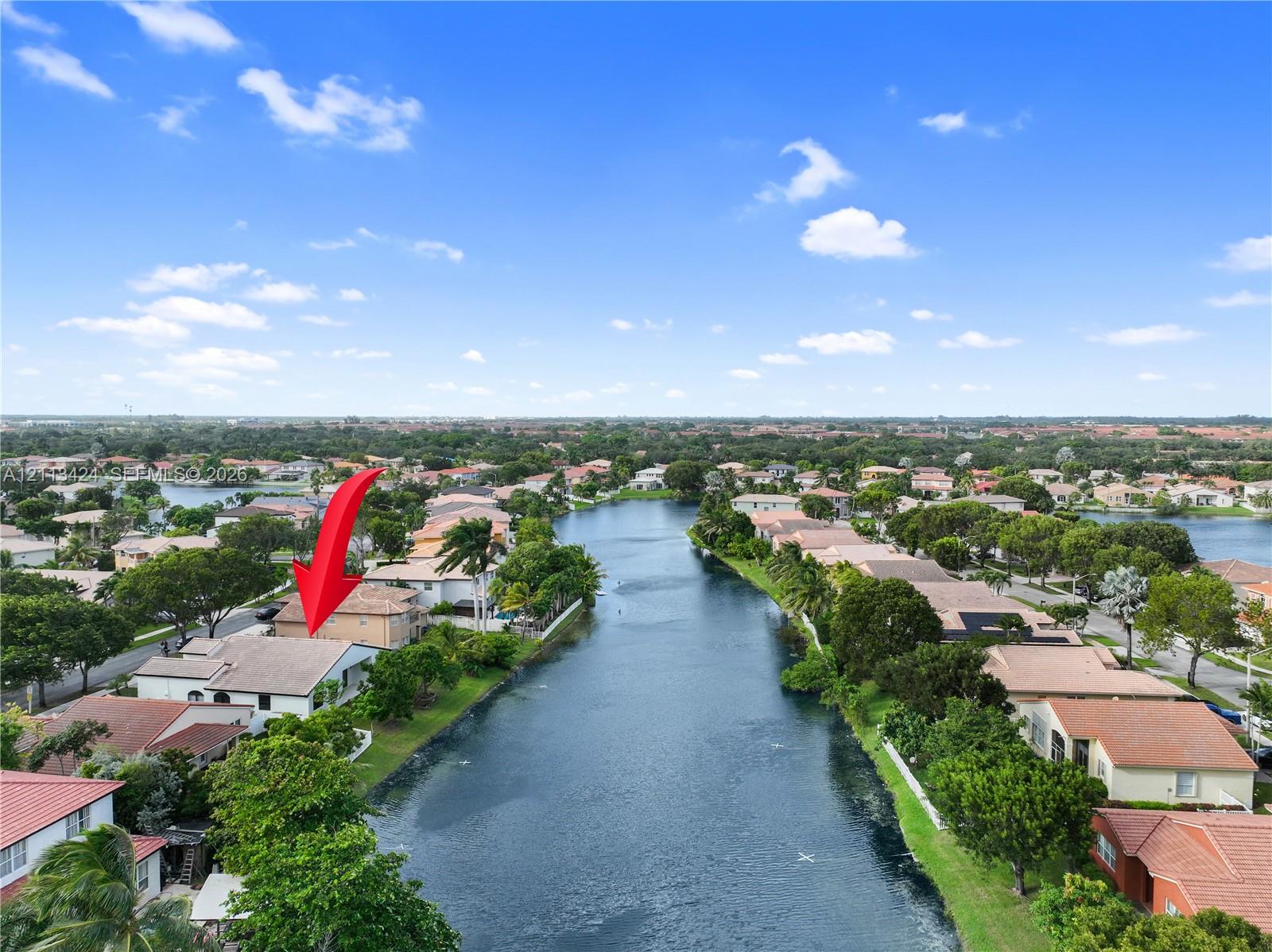 Waterfront property featuring a tile roof, stucco exterior, and direct water access