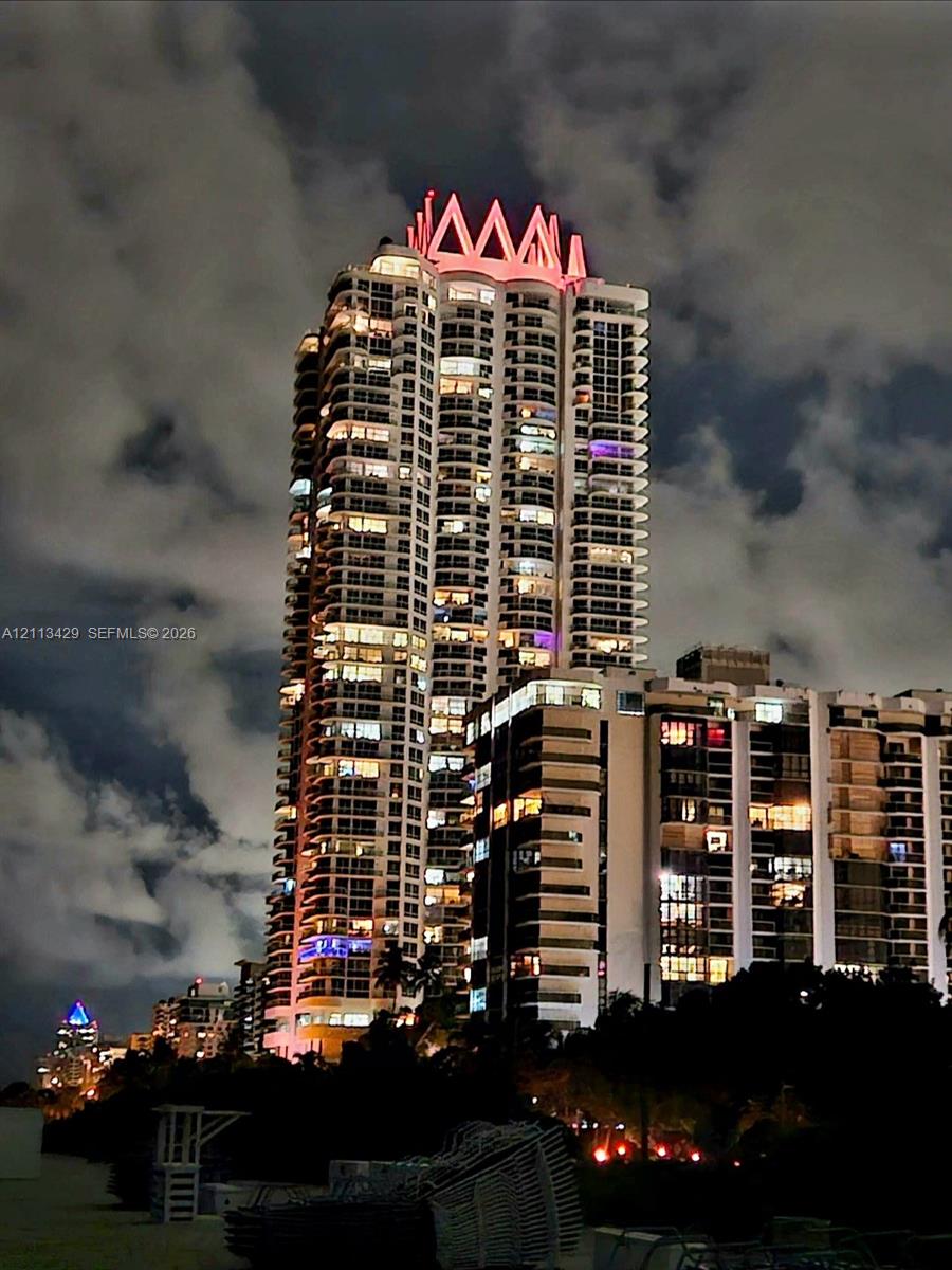 High-rise architectural structure featuring a prominent crown roof design, stacked balconies, and expansive glass exterior glazing