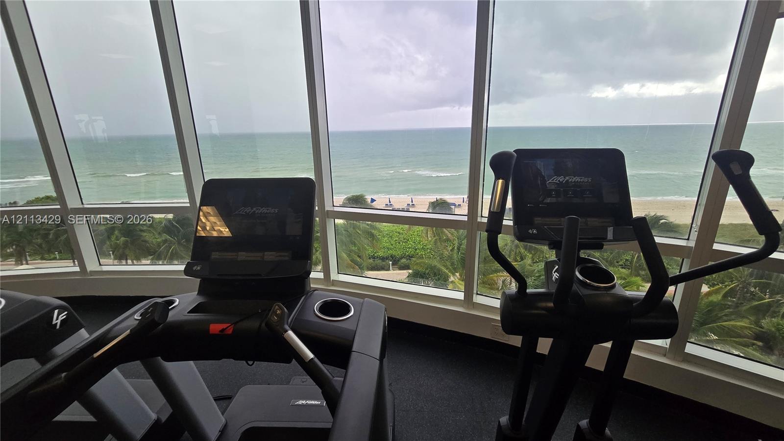 Fitness center featuring floor-to-ceiling windows and coastal scenery