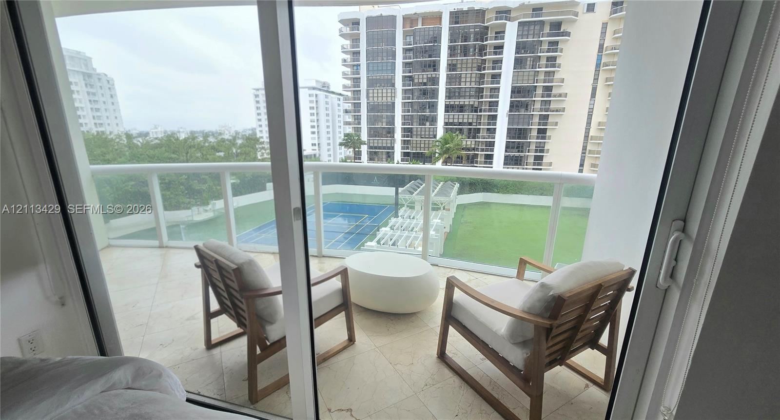 Private balcony featuring tile flooring and a glass-paneled railing