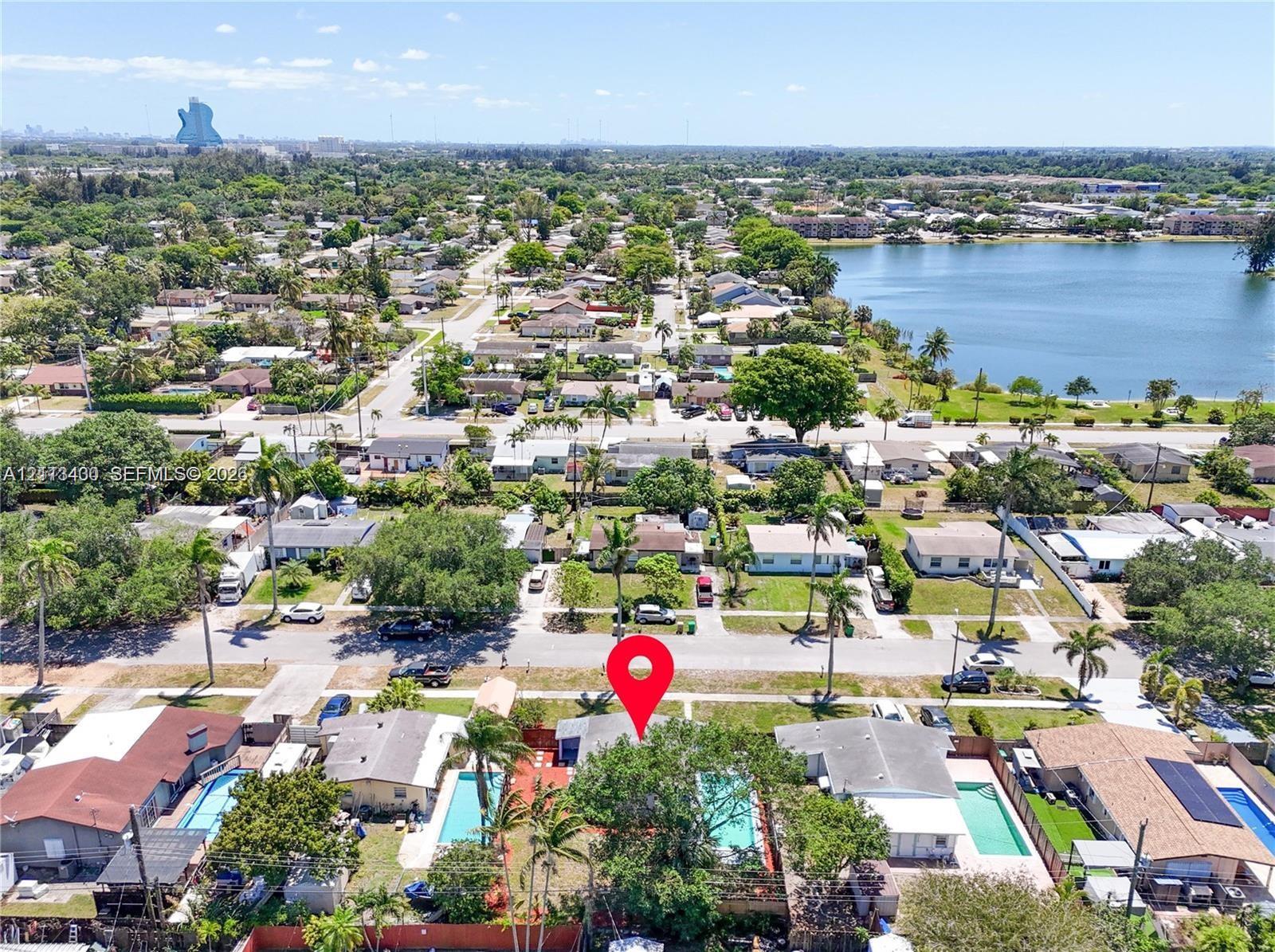 Aerial perspective of residential property featuring a private swimming pool, fenced perimeter, and mature canopy trees Aerial perspective of residential property featuring a private swimming pool, fenced perimeter, and mature canopy trees