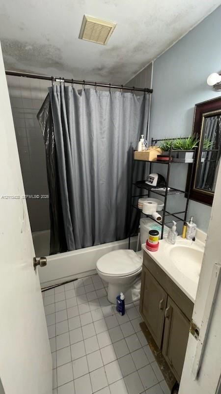 Bathroom featuring a porcelain vanity with a built-in sink, a standard tub and shower combination, ceramic tile flooring, and a wall-mounted medicine cabinet