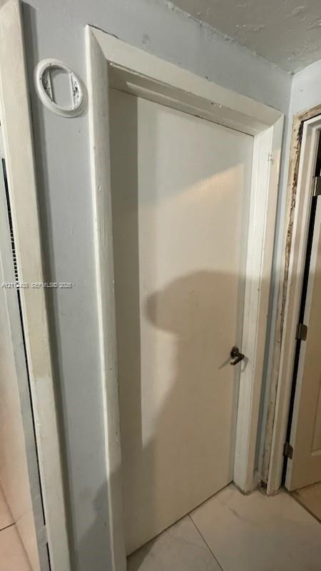 Solid core door featuring white painted finish, rectangular door casing, and metal lever handle hardware