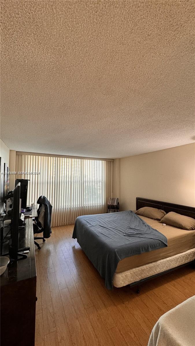 Wood-finish flooring and floor-to-ceiling vertical window blinds