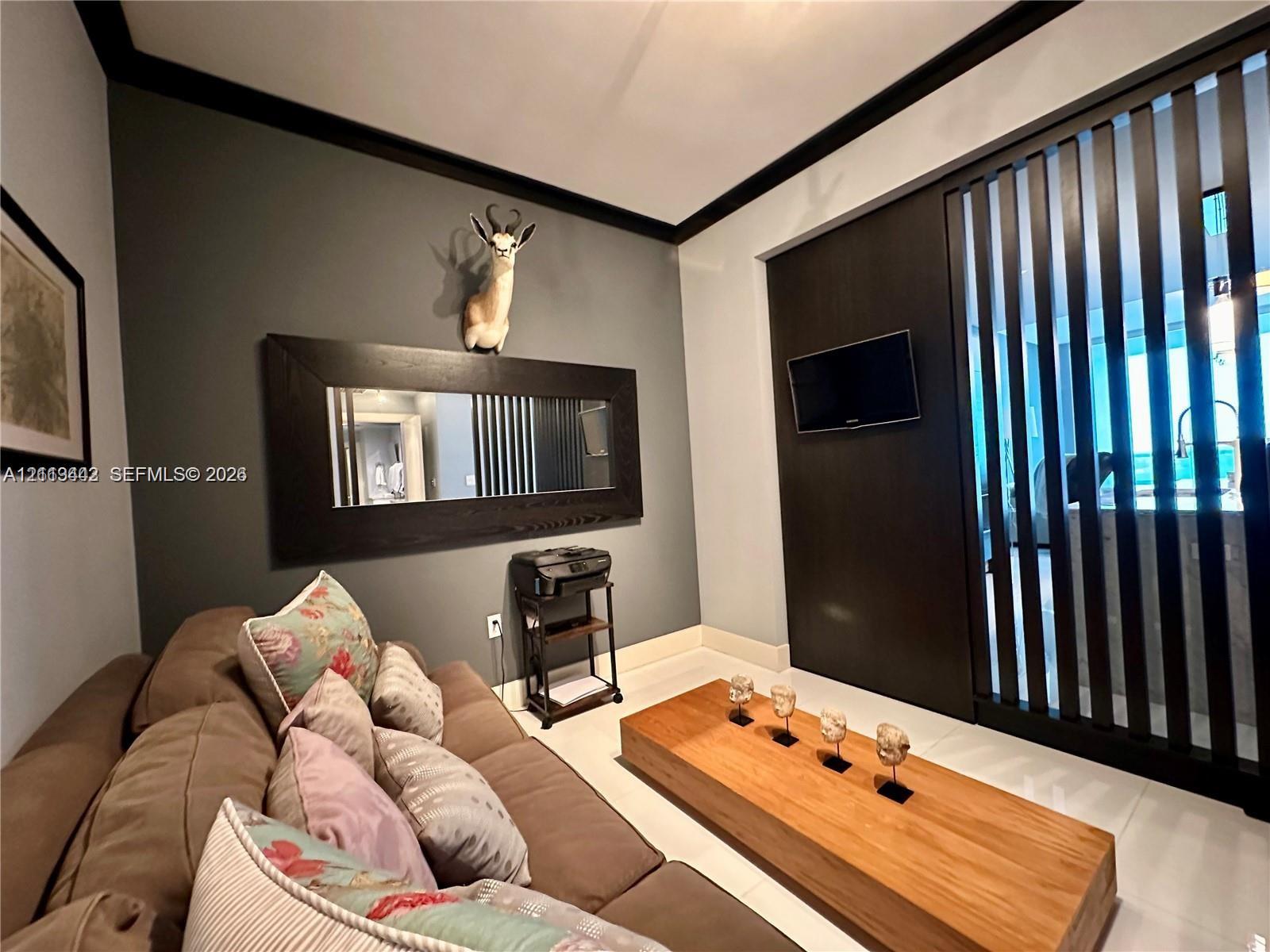 Dark-toned architectural accent wall with integrated vertical slat screening and large-format porcelain tile flooring throughout