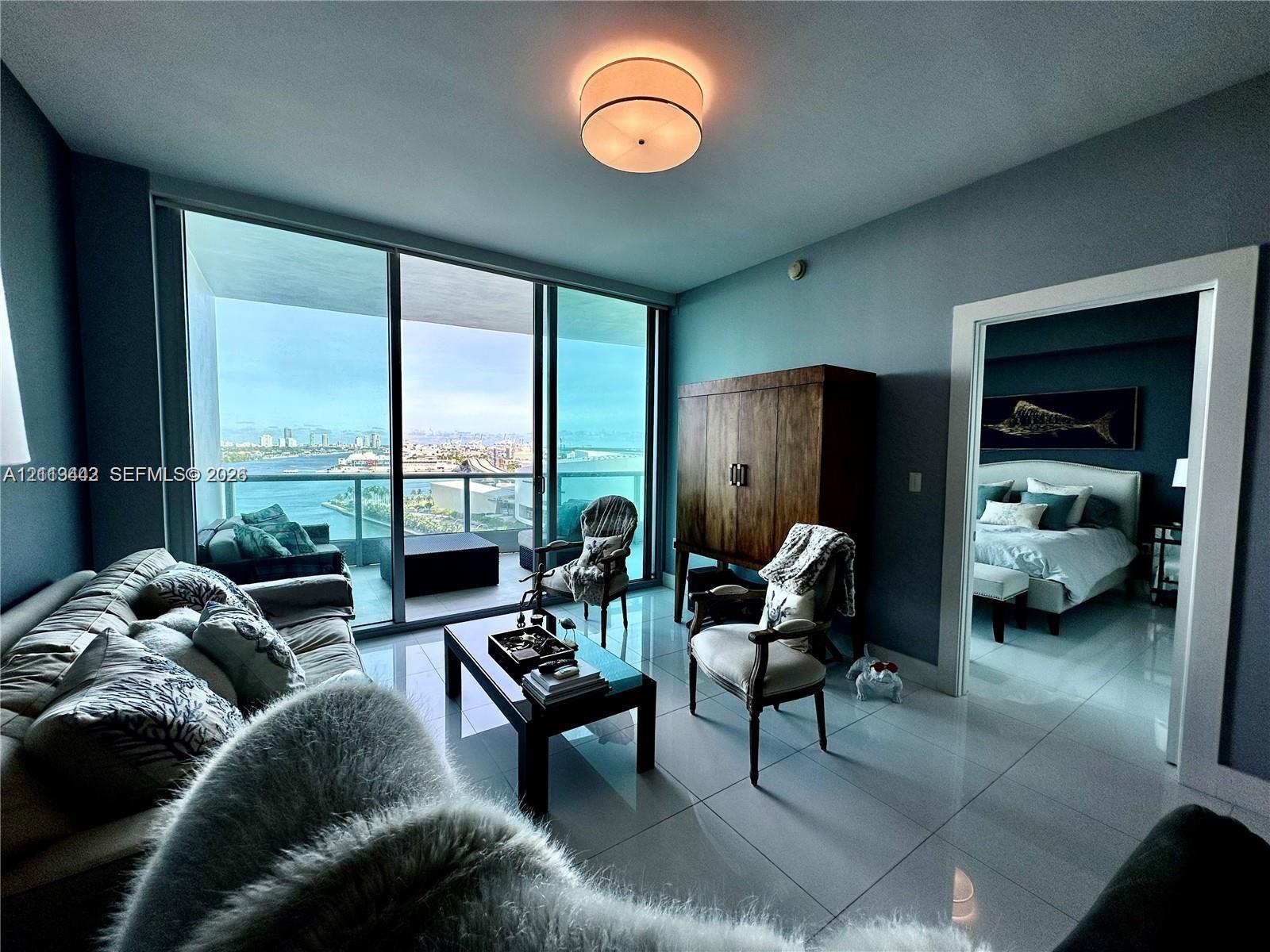 Floor-to-ceiling glass sliding doors, private balcony, polished tile flooring, and flush-mount drum ceiling light