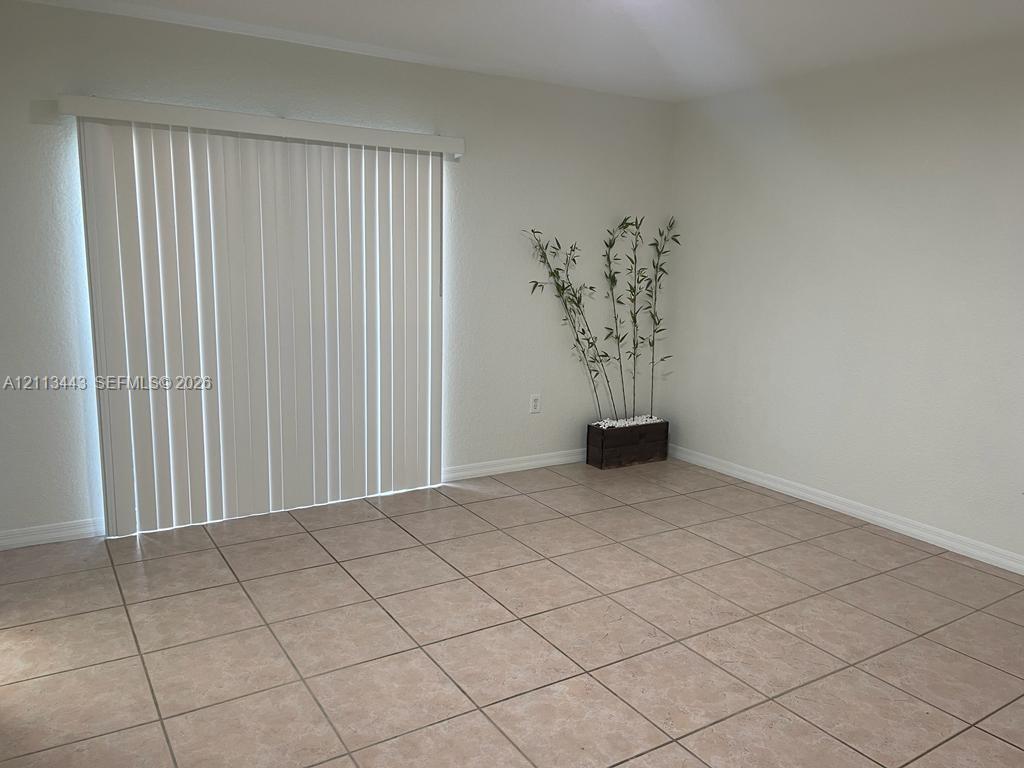 Ceramic tile flooring and white vertical sliding glass patio doors