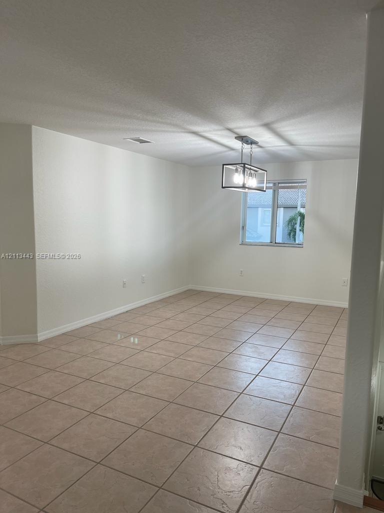 Neutral-toned ceramic tile flooring, rectangular window, and a geometric metal frame light fixture