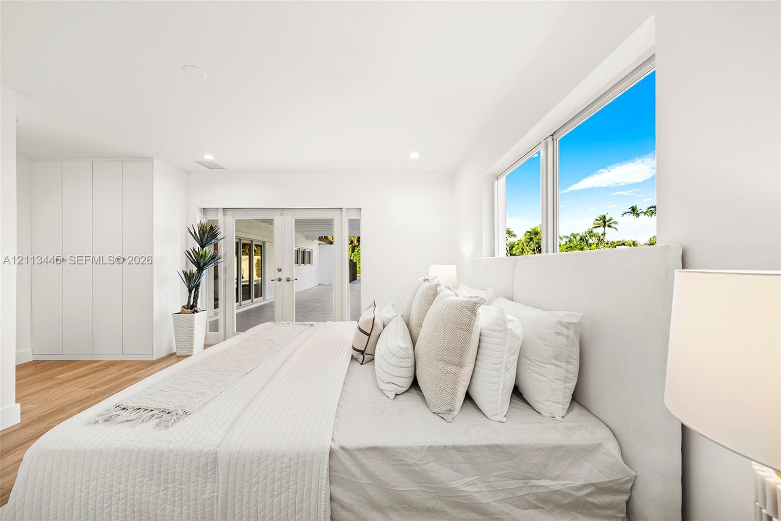 Room featuring wood-finish flooring, built-in floor-to-ceiling cabinetry, recessed lighting, and double-pane glass doors providing external access