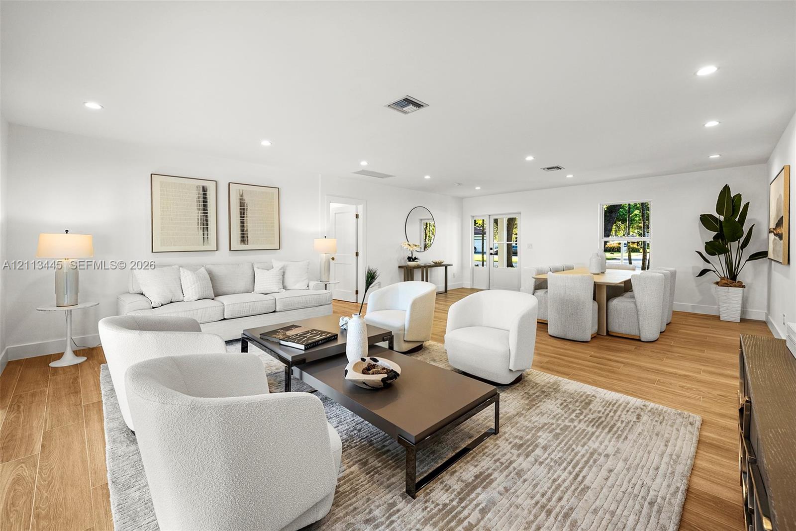 Open-concept interior featuring light-tone wood-finish flooring, recessed lighting, and crisp white walls Open-concept interior featuring light-tone wood-finish flooring, recessed lighting, and crisp white walls