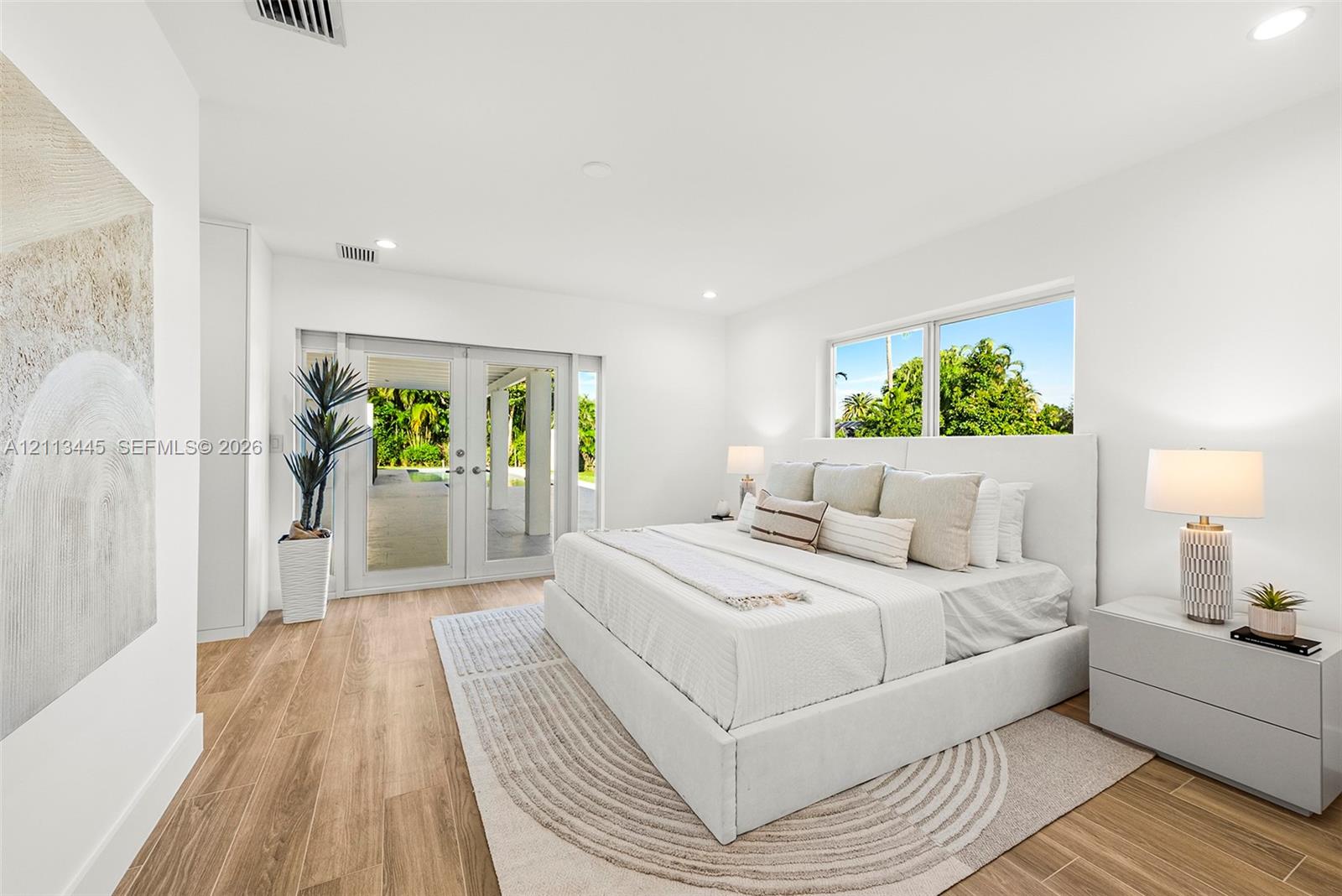 Room featuring wood-finish flooring, recessed lighting, and glass-paned double doors