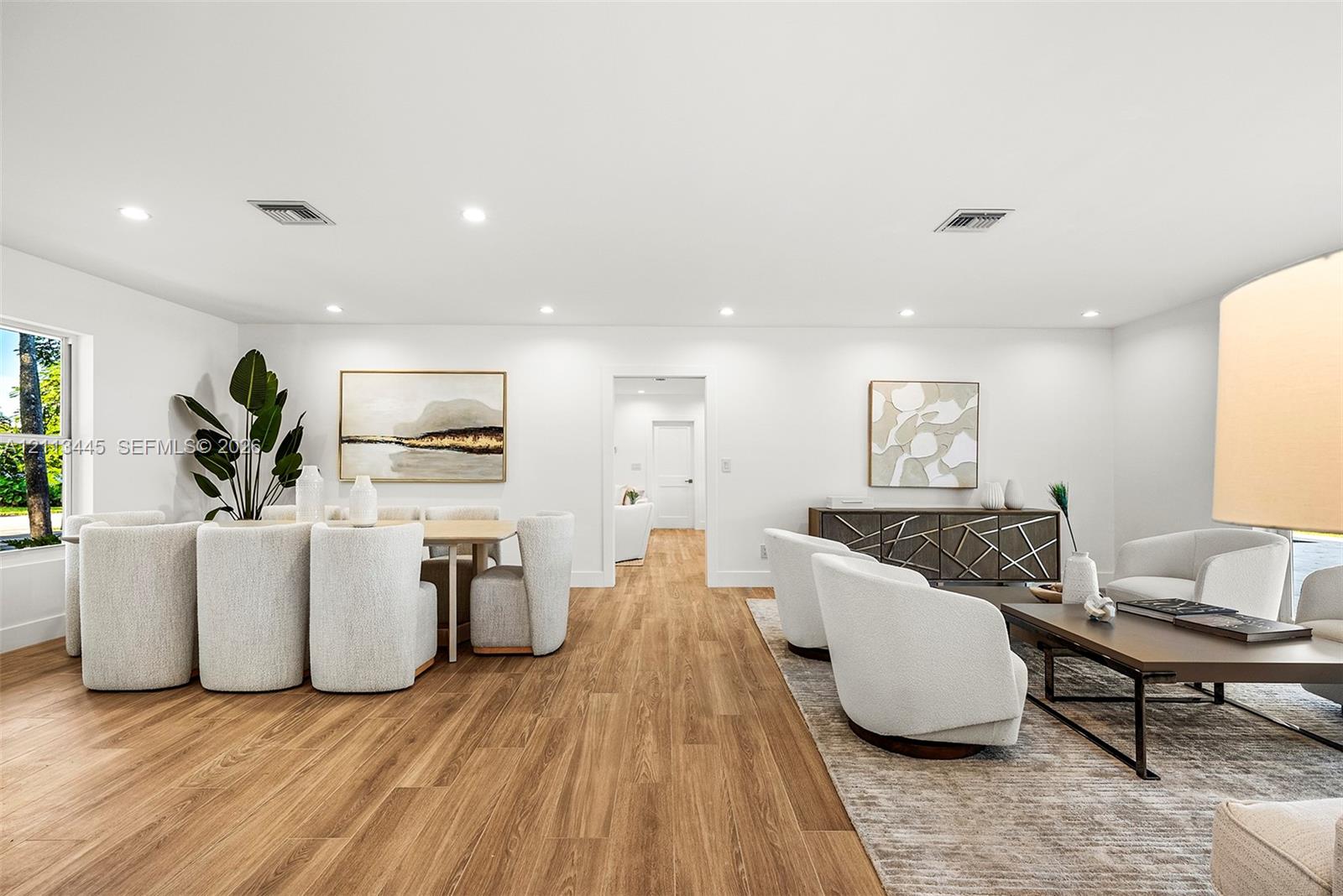 Open-concept interior featuring wood-finish flooring, recessed lighting, and crisp white wall finishes Open-concept interior featuring wood-finish flooring, recessed lighting, and crisp white wall finishes