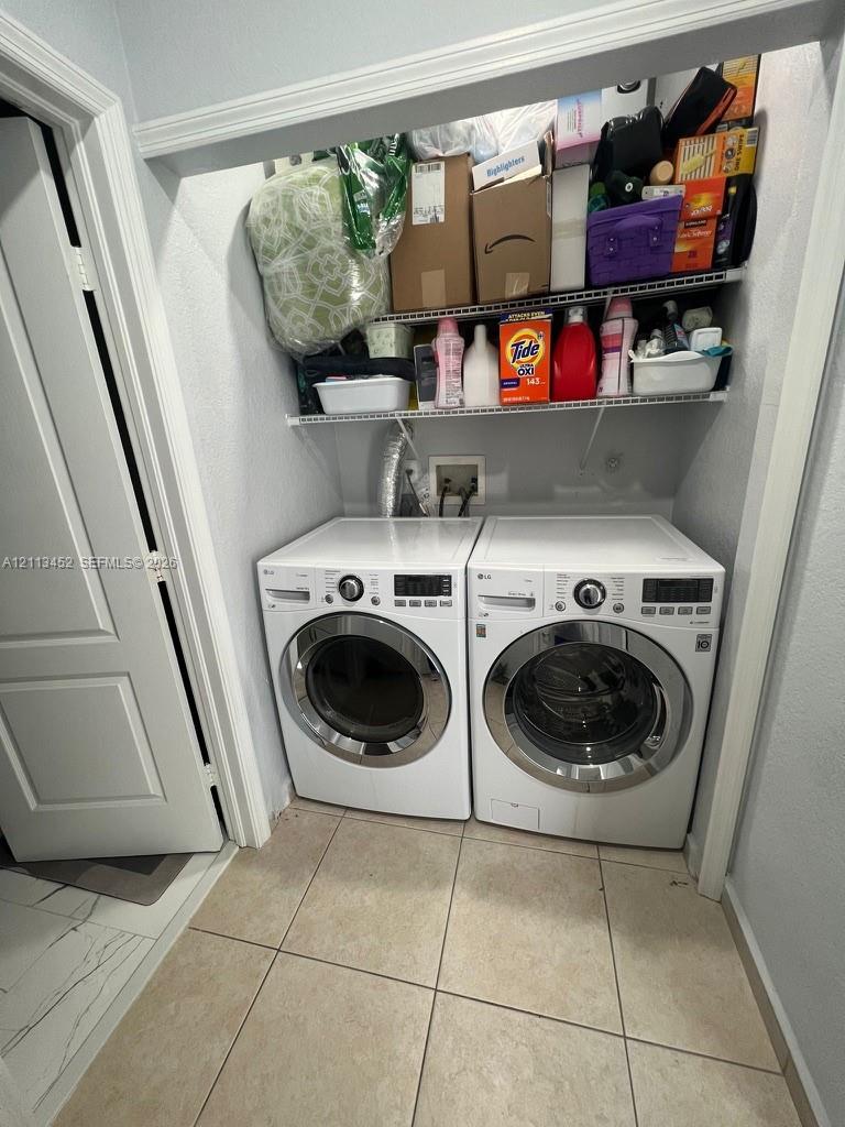 Laundry alcove featuring a pair of front-loading white appliances and built-in wire shelving