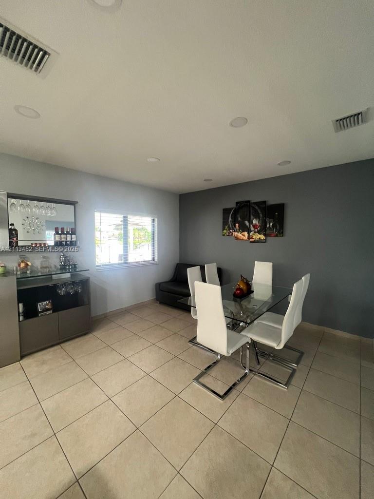 Ceramic tile flooring, recessed lighting, and built-in cabinetry with integrated mirror