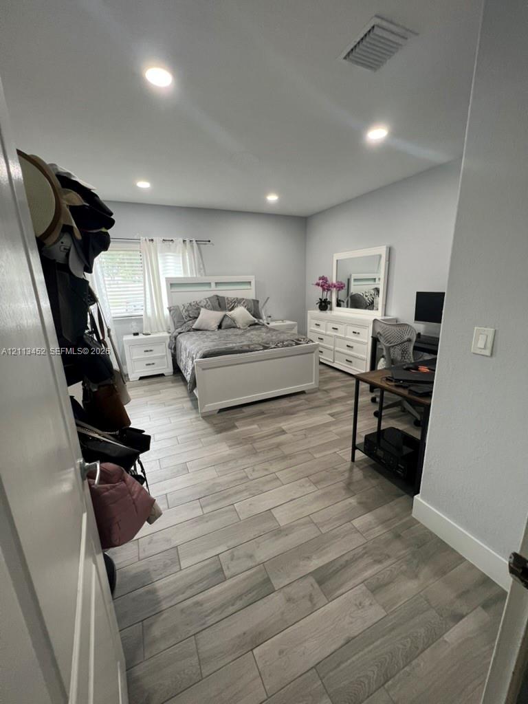 Room featuring wood-finish flooring, recessed lighting, and horizontal window blinds