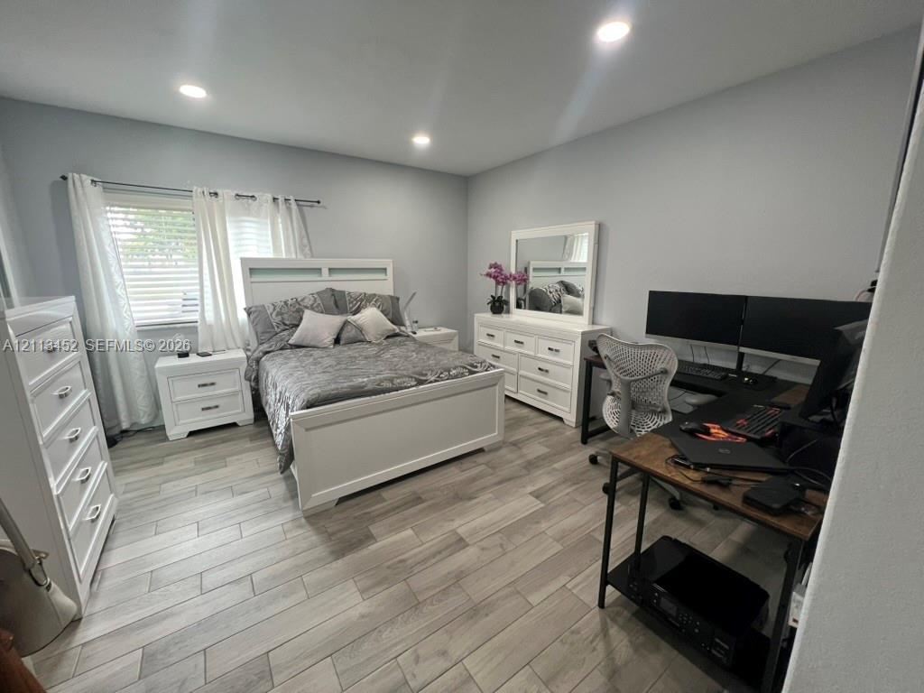 Neutral-toned space featuring wood-finish tile flooring and recessed ceiling lighting