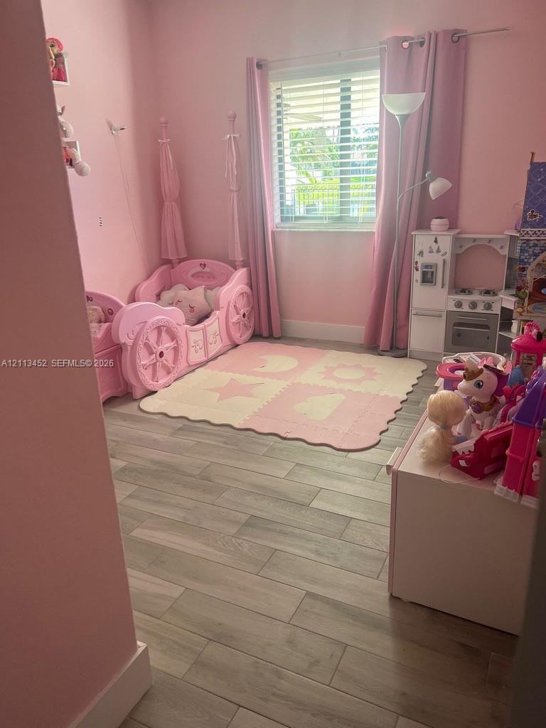 Wood-finish tile flooring and a dual-pane window with horizontal blinds