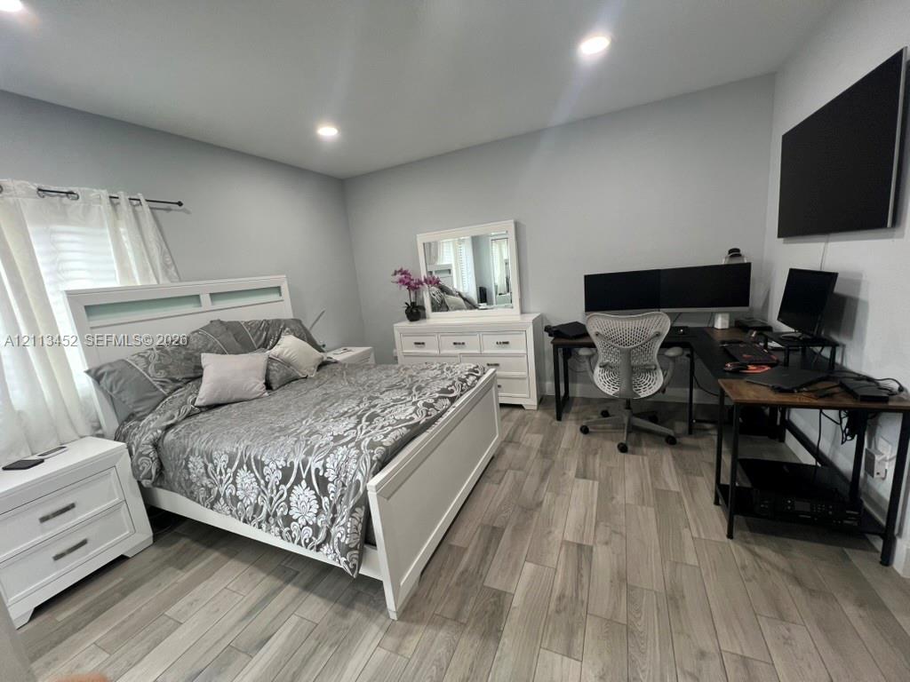 Neutral-toned room featuring wood-finish flooring and recessed lighting