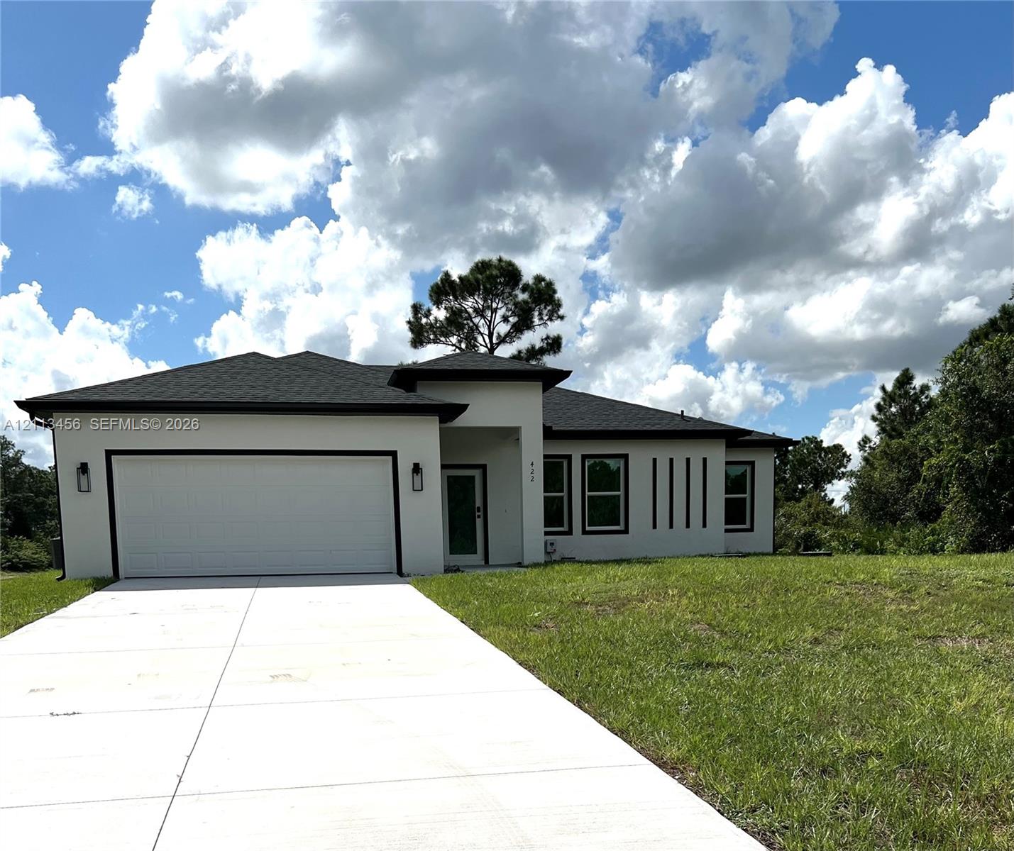 Single-story stucco exterior featuring a hip roof, two-car garage, concrete driveway, and recessed entryway Single-story stucco exterior featuring a hip roof, two-car garage, concrete driveway, and recessed entryway