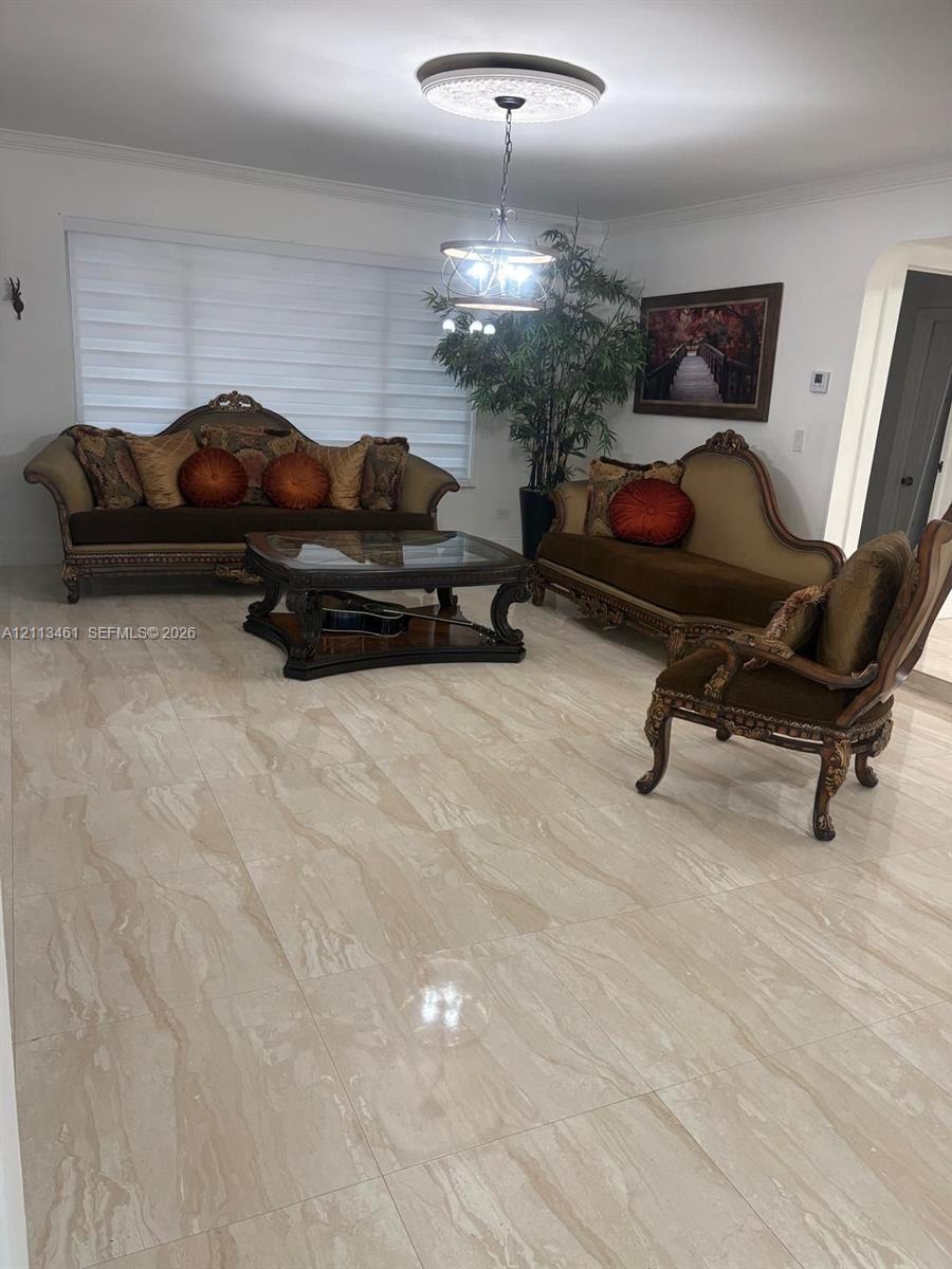 Large-format polished stone flooring, recessed ceiling medallion, and multi-tier hanging light fixture