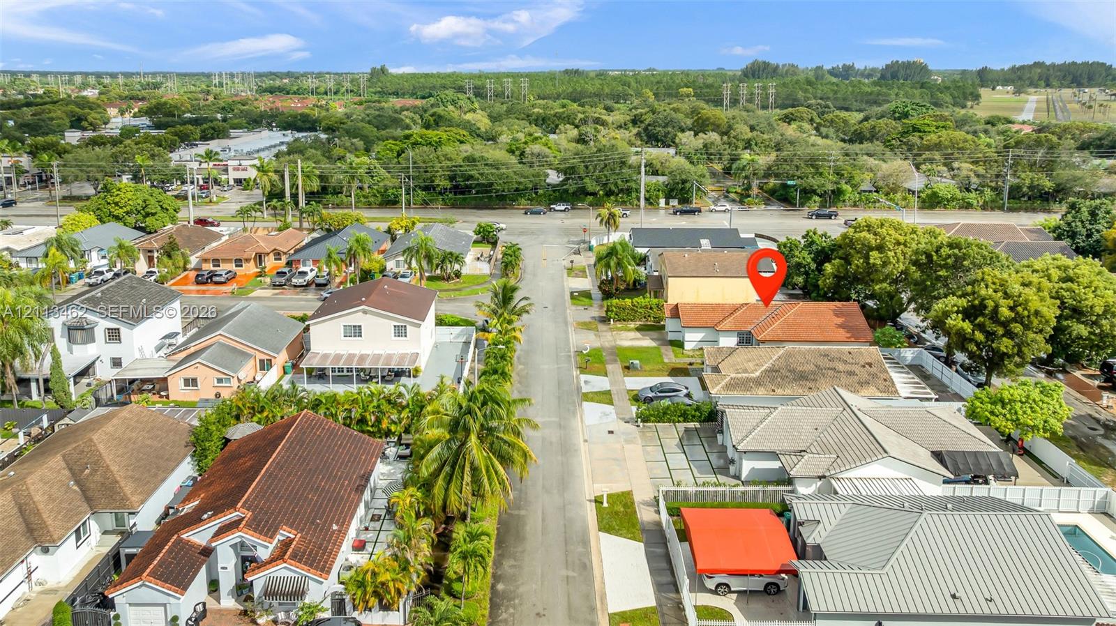 Aerial perspective of a residential property featuring a tiled roof, concrete driveway, and established perimeter landscaping