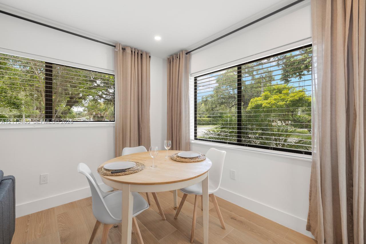 Light-filled room featuring wood-finish flooring, recessed lighting, and large dual-pane windows with horizontal blinds