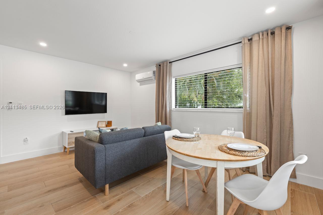 Interior space featuring wood-finish flooring, recessed lighting, and a wall-mounted climate control unit