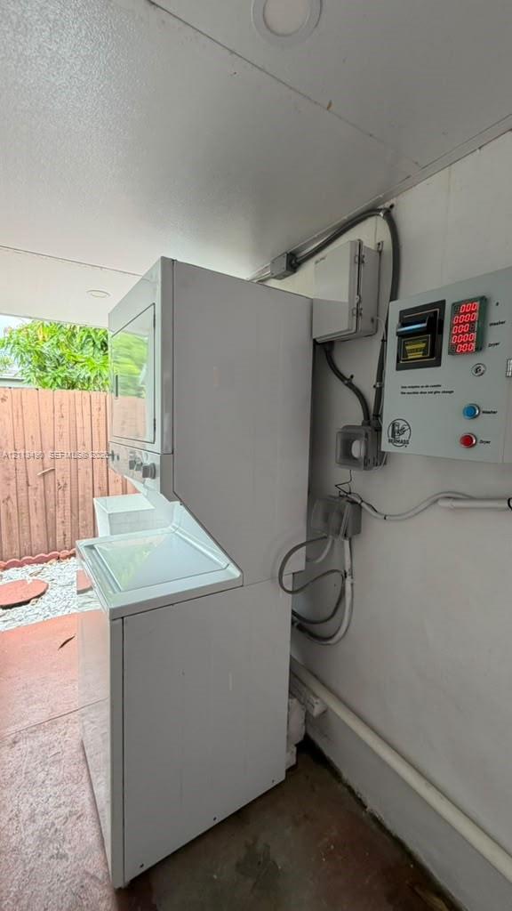 Stacked laundry unit with utility control panel and recessed ceiling lighting