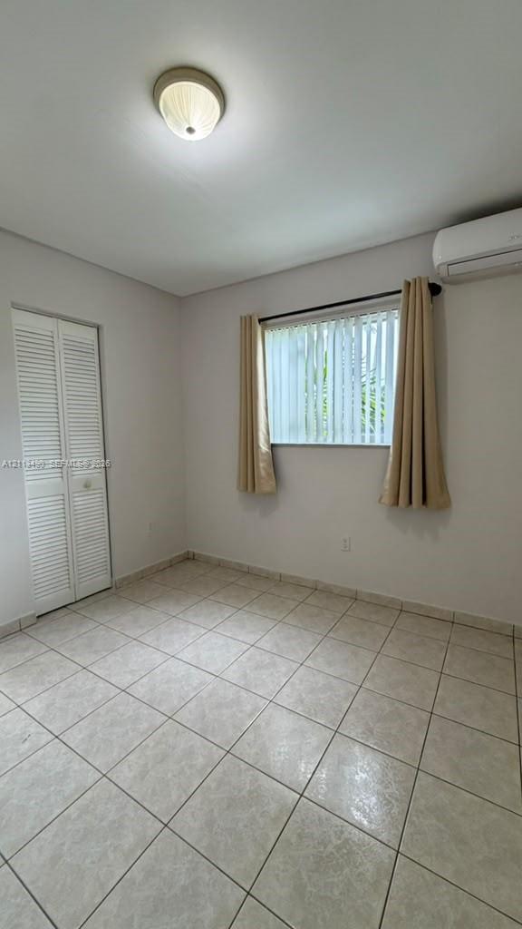 Ceramic tile flooring, wall-mounted ductless air conditioning unit, bi-fold closet doors, and flush-mount ceiling light fixture Ceramic tile flooring, wall-mounted ductless air conditioning unit, bi-fold closet doors, and flush-mount ceiling light fixture