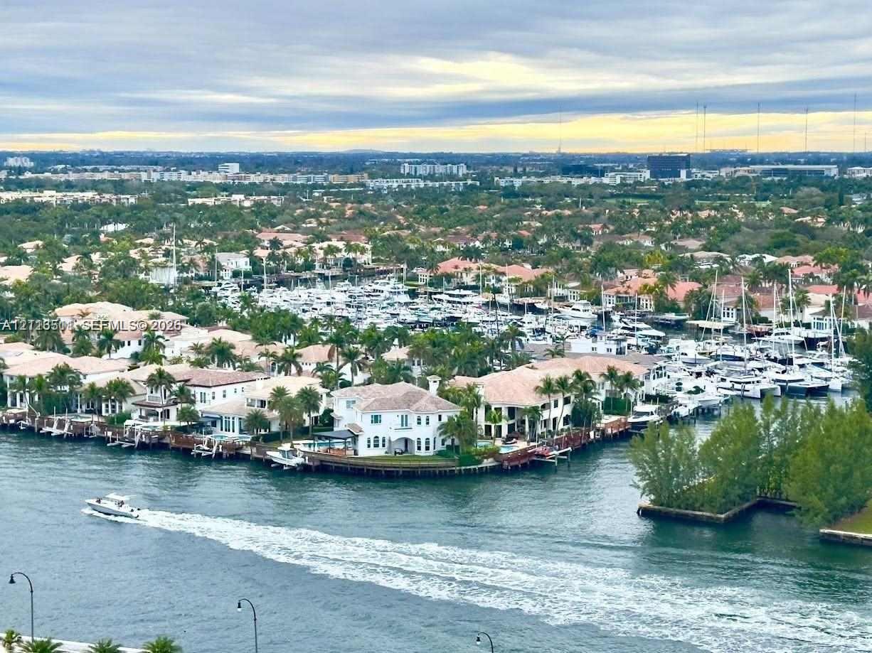 Aerial perspective of waterfront properties featuring deep-water access, private boat docks, paved sea walls, and mature palm landscaping along the canal