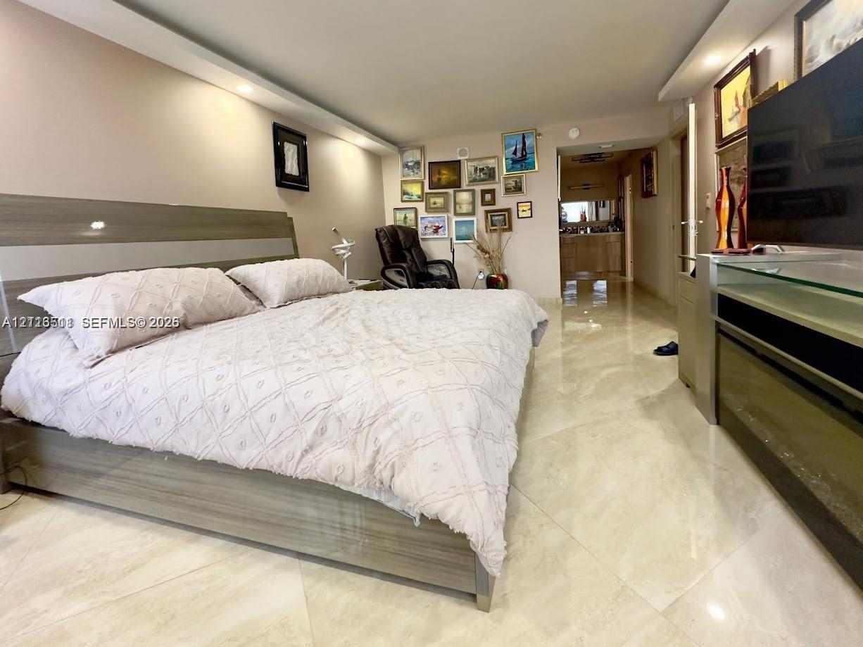 Polished stone flooring, recessed ceiling lighting, and custom built-in cabinetry featuring a wood-grain finish
