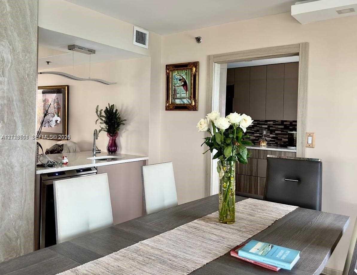 Wet bar featuring stone countertops, an under-counter beverage cooler, and a stainless steel sink