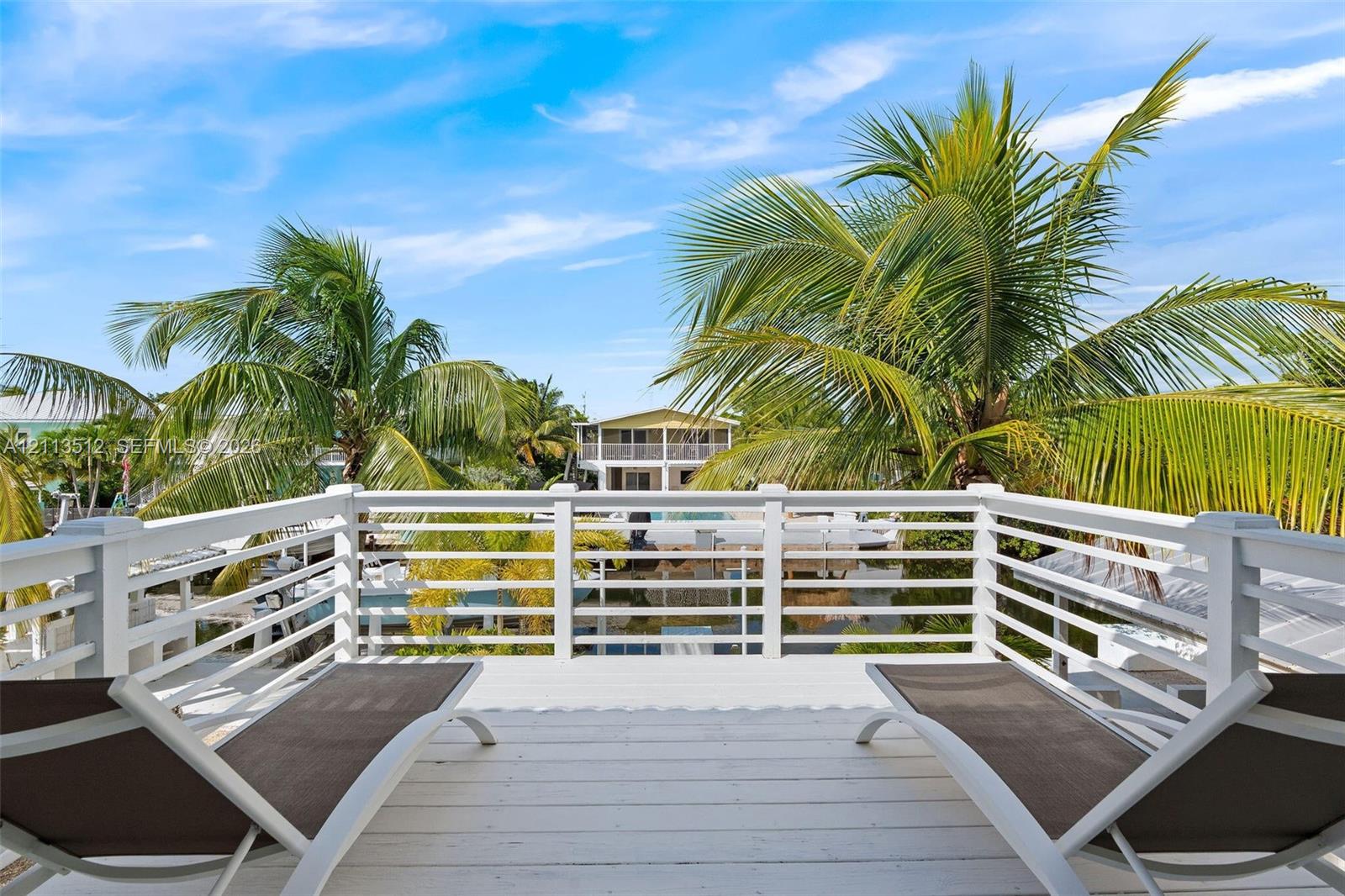 Elevated balcony featuring white painted wooden decking and white horizontal railing